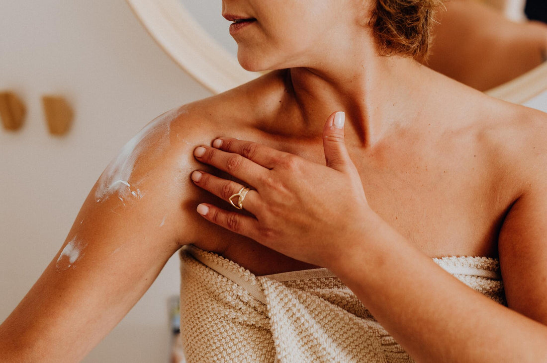 Woman rubbing lotion onto shoulder | magnesium lotion benefits